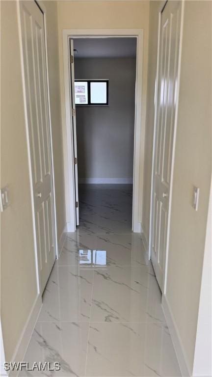 4802 Nora Ave N, Lehigh Acres, FL 33971 - hallway featuring baseboards and light marble finish flooring