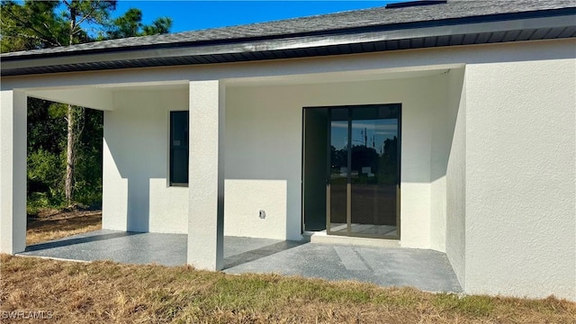 4802 Nora Ave N, Lehigh Acres, FL 33971 - doorway to property with stucco siding and a patio area