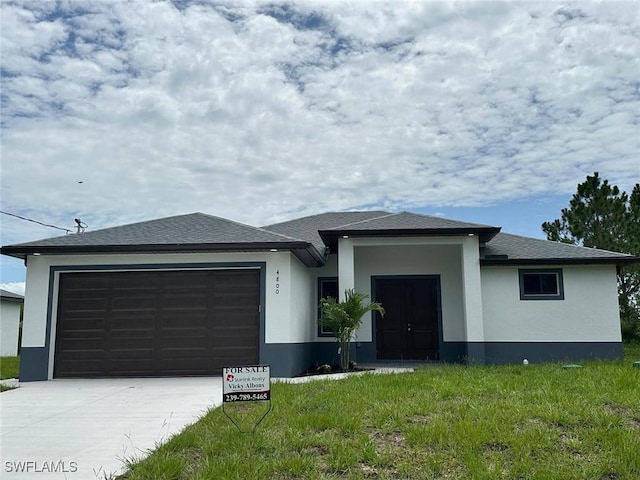 4802 Nora Ave N, Lehigh Acres, FL 33971 - prairie-style home with stucco siding, a garage, driveway, and roof with shingles