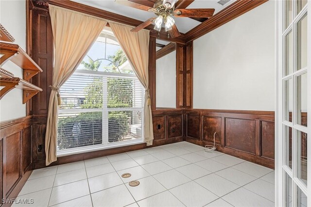 1207 SW 52nd Ter, Cape Coral, FL 33914 - empty room featuring ceiling fan, a wainscoted wall, light tile patterned flooring, crown molding, and a decorative wall