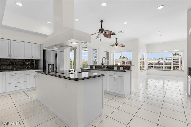 1207 SW 52nd Ter, Cape Coral, FL 33914 - kitchen featuring a kitchen island with sink, stainless steel refrigerator with ice dispenser, a sink, black electric cooktop, and light tile patterned floors