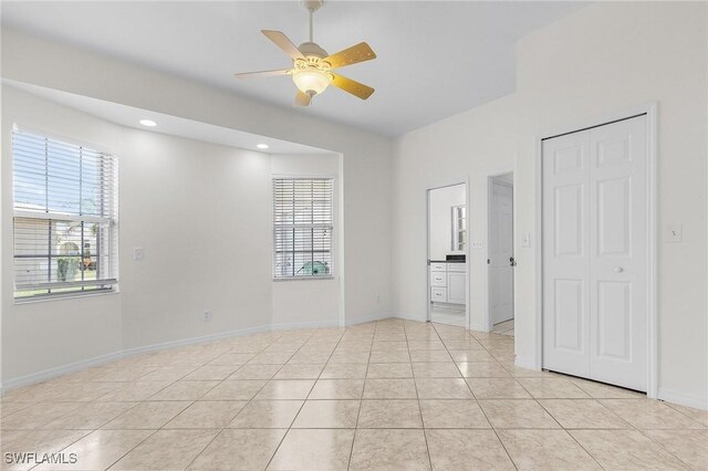 1207 SW 52nd Ter, Cape Coral, FL 33914 - unfurnished bedroom featuring ensuite bath, light tile patterned flooring, ceiling fan, baseboards, and recessed lighting