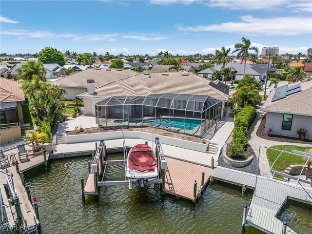 1207 SW 52nd Ter, Cape Coral, FL 33914 - dock area featuring boat lift, a residential view, and an outdoor pool