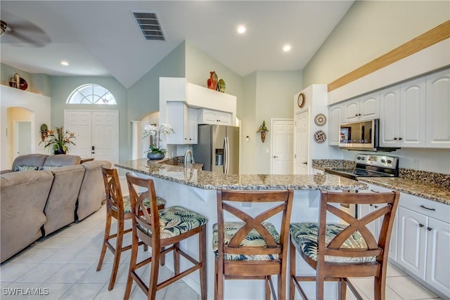 3914 SW 17th Ave, Cape Coral, FL 33914 - kitchen featuring open floor plan, visible vents, a kitchen breakfast bar, and stainless steel appliances