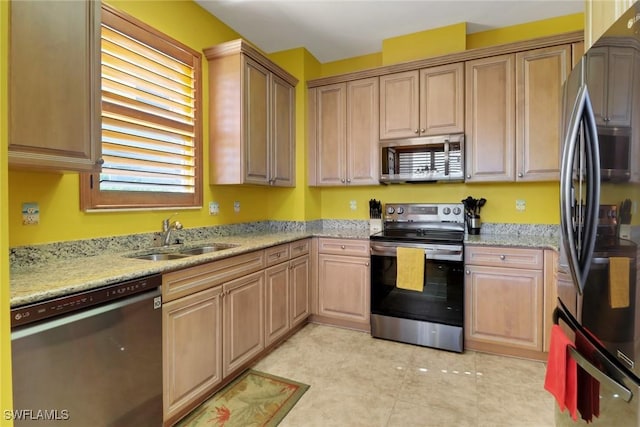 16580 Goldenrod Ln Unit 103, Alva, FL 33920 - kitchen with light tile patterned flooring, a sink, stainless steel appliances, and light stone counters