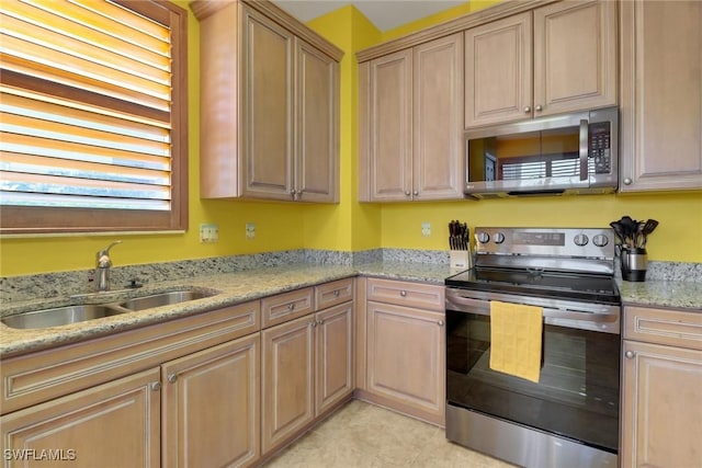 16580 Goldenrod Ln Unit 103, Alva, FL 33920 - kitchen with light tile patterned floors, light brown cabinetry, a sink, light stone counters, and appliances with stainless steel finishes