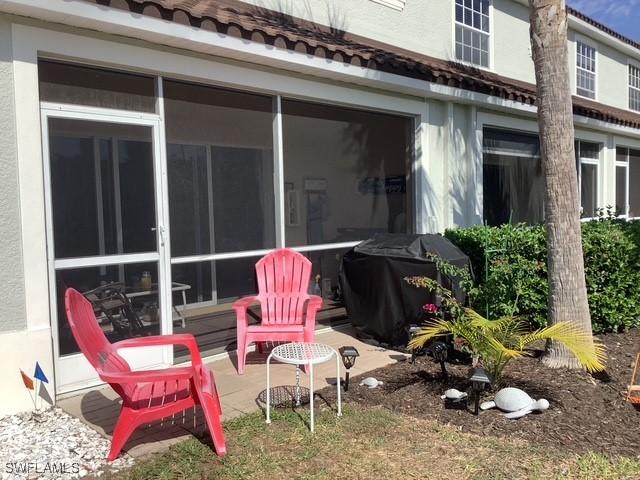 11735 Eros Rd, Lehigh Acres, FL 33971 - back of house with stucco siding, a sunroom, and a tile roof
