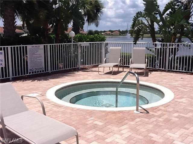 11735 Eros Rd, Lehigh Acres, FL 33971 - view of pool featuring a community hot tub, fence, and a patio area
