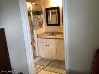 11735 Eros Rd, Lehigh Acres, FL 33971 - bathroom with tile patterned floors, vanity, and a shower stall