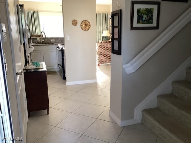 11735 Eros Rd, Lehigh Acres, FL 33971 - corridor featuring baseboards, stairs, a sink, and light tile patterned floors