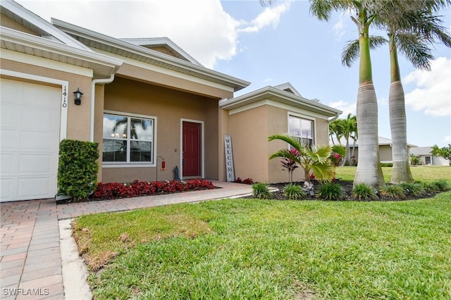 1410 SW 38th St, Cape Coral, FL 33914 - entrance to property with stucco siding, a lawn, and an attached garage