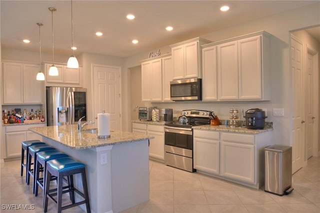 1410 SW 38th St, Cape Coral, FL 33914 - kitchen featuring appliances with stainless steel finishes, recessed lighting, light tile patterned floors, white cabinets, and a breakfast bar