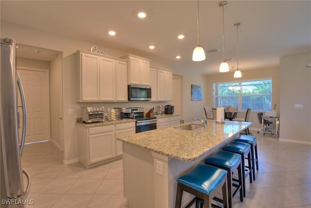 1410 SW 38th St, Cape Coral, FL 33914 - kitchen featuring stainless steel appliances, a sink, light tile patterned floors, white cabinets, and recessed lighting