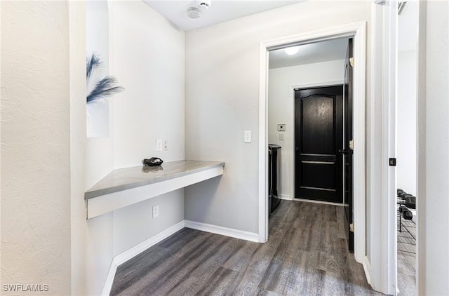 hallway featuring baseboards and dark wood-style floors