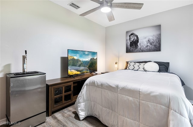 bedroom featuring ceiling fan, wood finished floors, and visible vents
