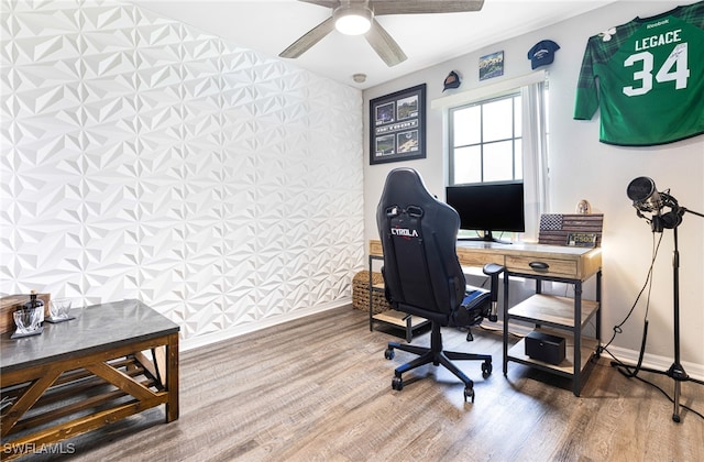 home office with a ceiling fan, baseboards, wallpapered walls, and wood finished floors