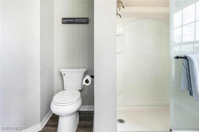 full bathroom featuring toilet, baseboards, and a stall shower