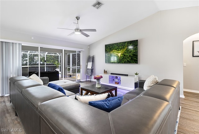 living area featuring a ceiling fan, visible vents, wood finished floors, and vaulted ceiling