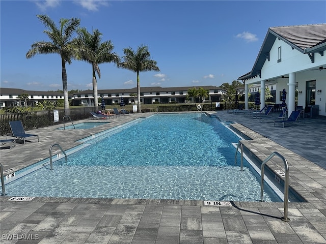 community pool featuring fence and a patio