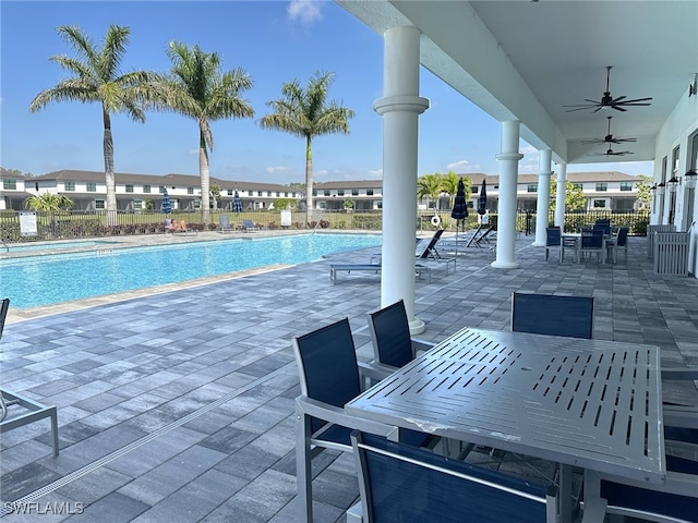 community pool with a patio, fence, outdoor dining area, and a ceiling fan