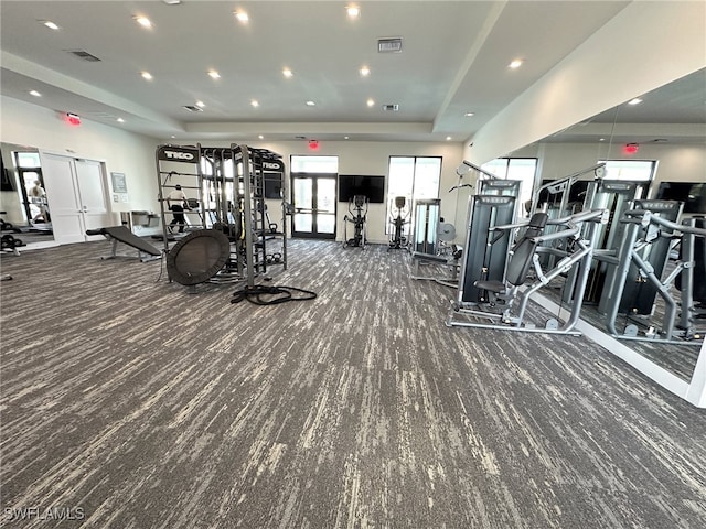 exercise room with french doors, a tray ceiling, and carpet flooring