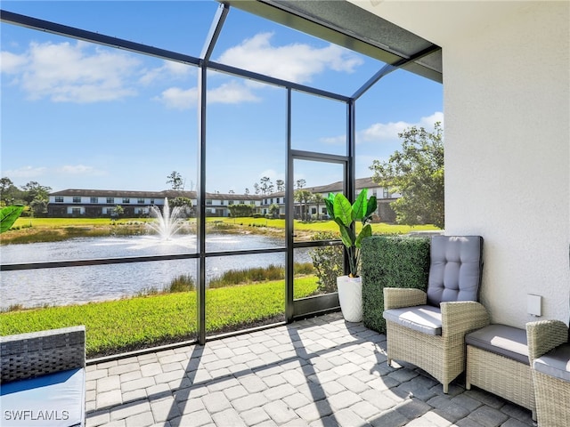 sunroom / solarium with a residential view and a water view