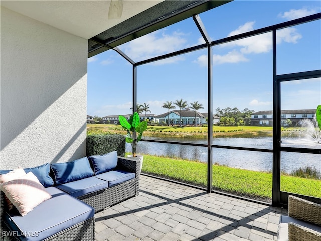 sunroom with ceiling fan, a water view, an outdoor hangout area, and a residential view