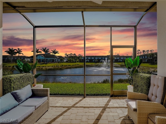 sunroom / solarium featuring a residential view and a water view