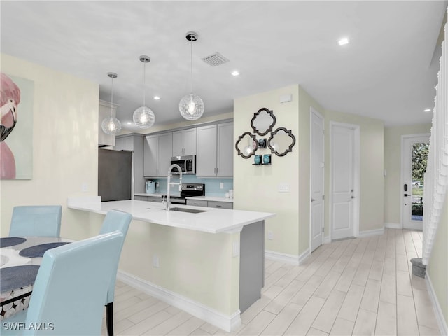 kitchen with gray cabinets, visible vents, decorative light fixtures, light countertops, and appliances with stainless steel finishes