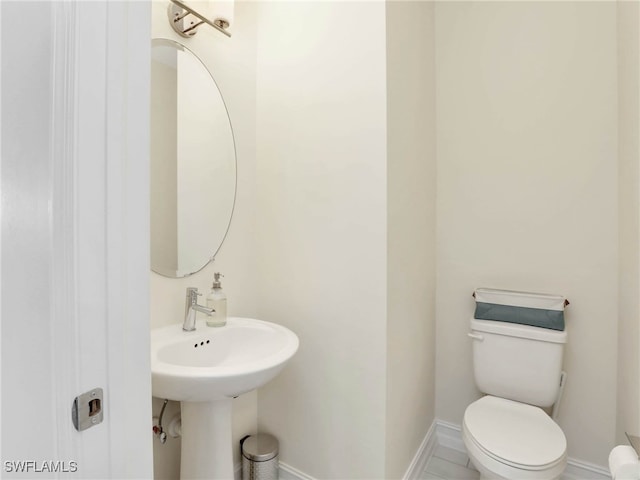 bathroom featuring toilet and baseboards