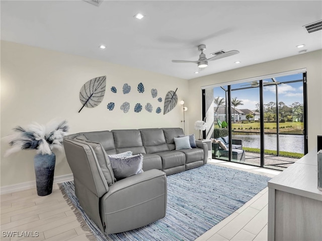 living area with recessed lighting, a water view, light wood-type flooring, a ceiling fan, and visible vents
