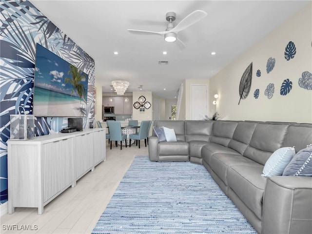 living area with recessed lighting, visible vents, and ceiling fan with notable chandelier