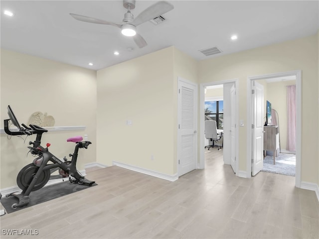exercise area featuring visible vents, light wood-type flooring, a ceiling fan, and baseboards