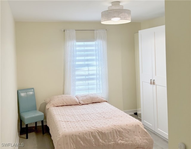 bedroom featuring wood finished floors and baseboards