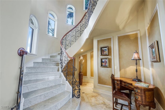 580 S Heathwood Dr, Marco Island, FL 34145 - stairs featuring marble finish floor, plenty of natural light, and a towering ceiling