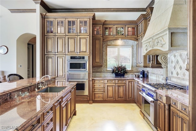 580 S Heathwood Dr, Marco Island, FL 34145 - kitchen with ornamental molding, high end stainless steel range oven, a sink, arched walkways, and light stone counters
