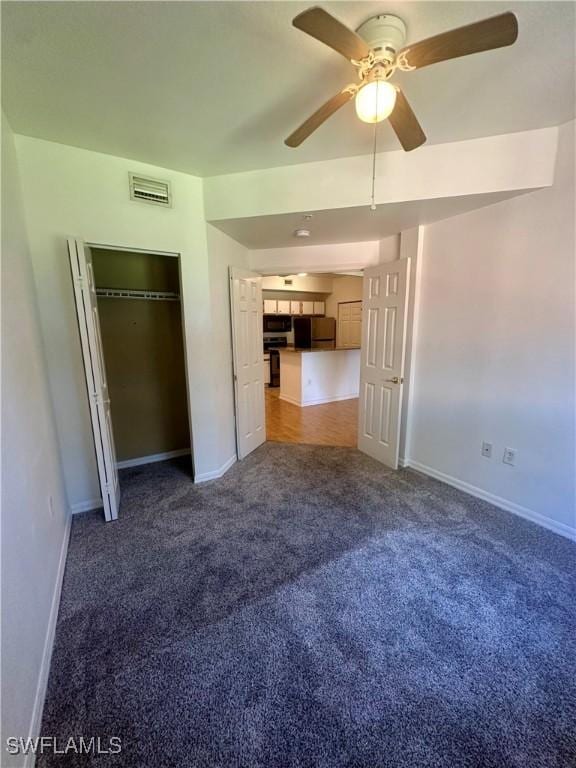 unfurnished bedroom with baseboards, carpet floors, visible vents, and refrigerator