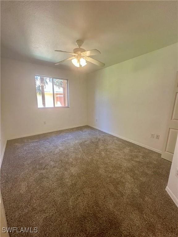 carpeted empty room with baseboards and a ceiling fan
