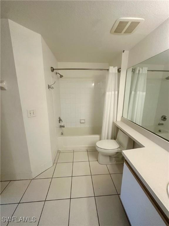 bathroom with tile patterned floors, toilet, vanity, shower / tub combo, and visible vents
