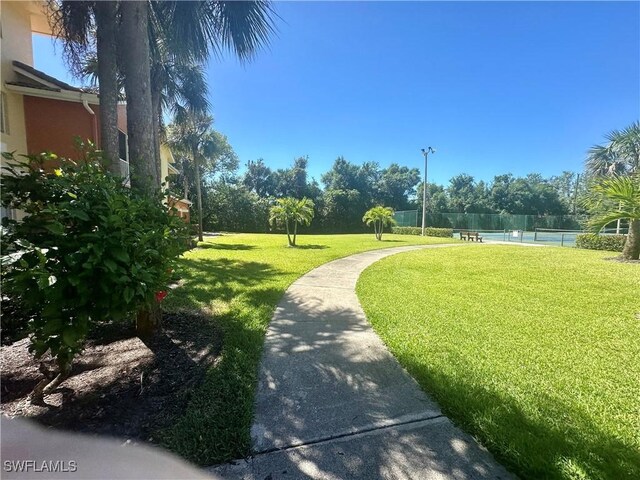 view of community with a lawn and fence