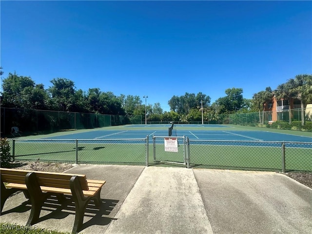 view of tennis court featuring a gate and fence