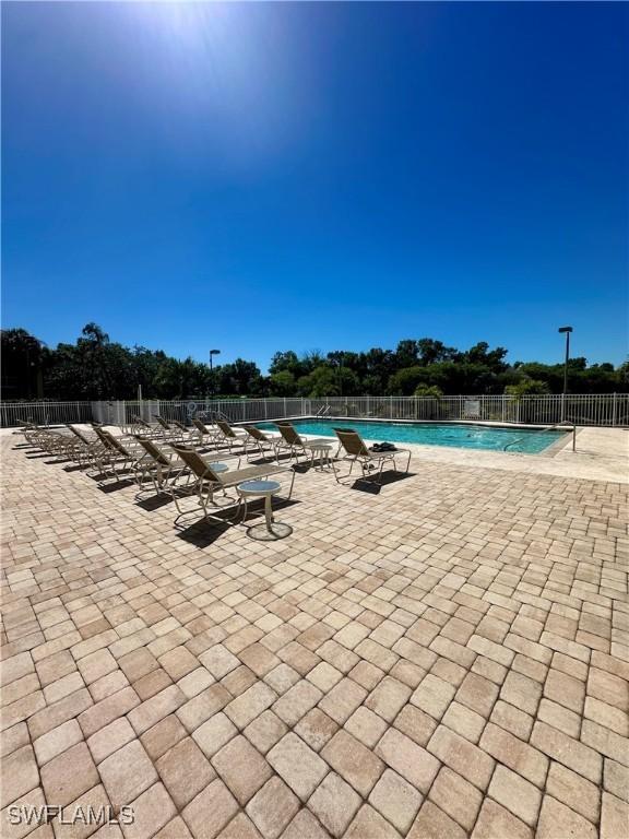 community pool featuring a patio and fence