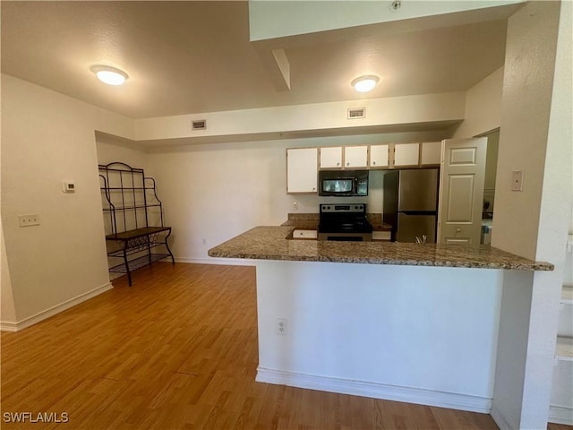 kitchen with white cabinetry, baseboards, light wood-style flooring, a peninsula, and appliances with stainless steel finishes