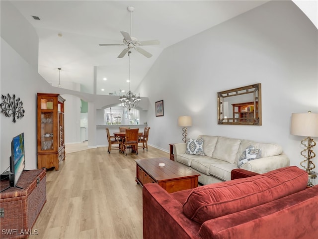 5774 Greenwood Cir Unit 64, Naples, FL 34112 - living room featuring light wood-type flooring, high vaulted ceiling, ceiling fan with notable chandelier, arched walkways, and visible vents