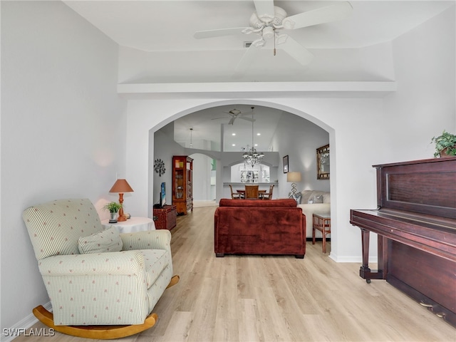5774 Greenwood Cir Unit 64, Naples, FL 34112 - living room featuring arched walkways, baseboards, wood finished floors, and ceiling fan with notable chandelier