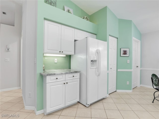 5774 Greenwood Cir Unit 64, Naples, FL 34112 - kitchen featuring decorative backsplash, baseboards, white fridge with ice dispenser, white cabinetry, and light tile patterned floors