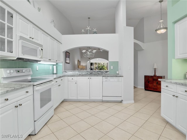 5774 Greenwood Cir Unit 64, Naples, FL 34112 - kitchen featuring a chandelier, white appliances, arched walkways, backsplash, and light tile patterned floors