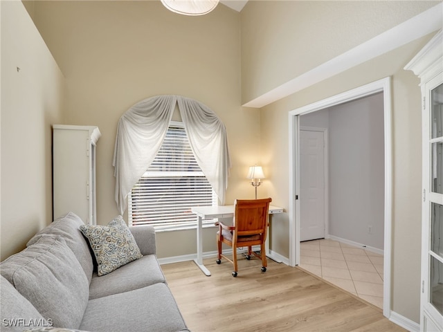 5774 Greenwood Cir Unit 64, Naples, FL 34112 - sitting room with a towering ceiling, baseboards, and wood finished floors