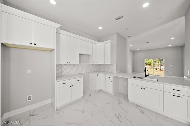 kitchen featuring backsplash, a sink, recessed lighting, and visible vents