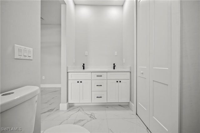 1034 Green Field St, Lehigh Acres, FL 33974 - bathroom featuring toilet, marble look tile flooring, baseboards, and double vanity